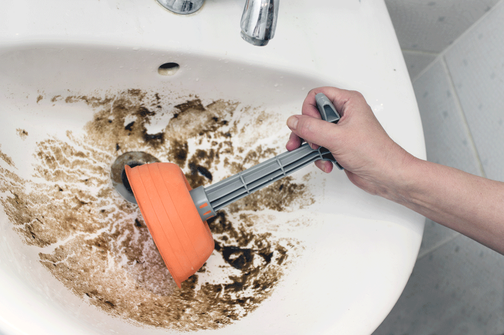 lady using plunger to drain clogged sink drain cleaning katy tx sugarland tx 