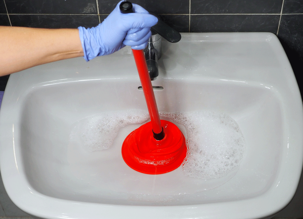 red pluger unclogging drain in bathroom | drain cleaning katy tx sugarland tx 