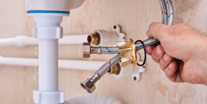 man holding cold and heat line to connect to pipe | plumbing repair katy tx sugarland tx